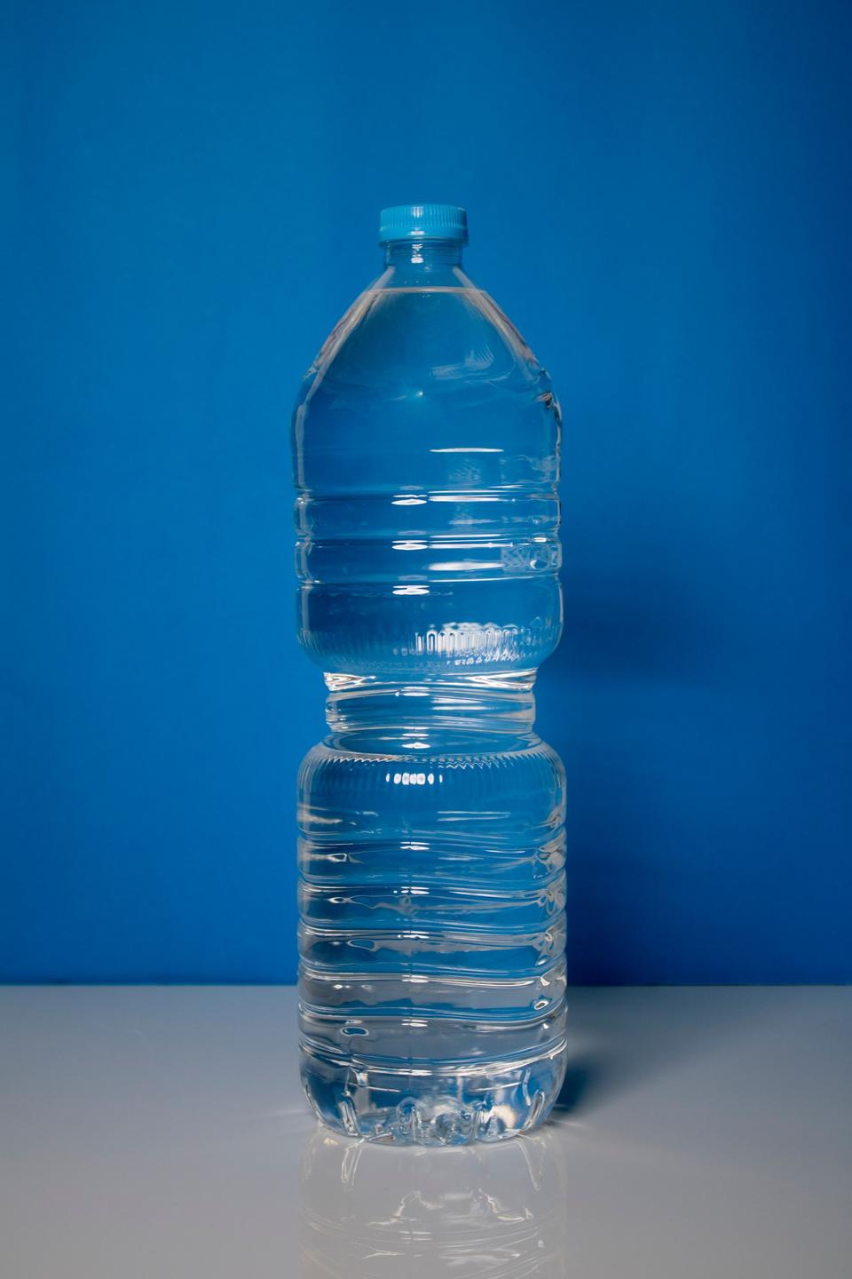 A sealed water bottle against a blue background